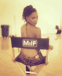 a woman sitting in a folding chair with the miff logo on it's back