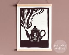 a black and white drawing of a teapot hanging on a wall with the words printable wall art below it