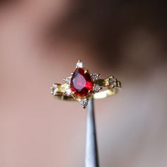 a close up of a ring with a red stone