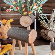 two wooden logs with flowers in them sitting on a table next to other wood items