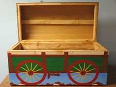 an open wooden box with wheels painted on it's sides, sitting on a table