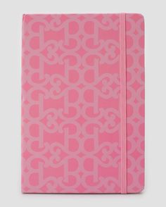 a pink notebook with monogramed letters on the front and bottom, in bright pink