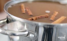 a pot filled with liquid and cinnamon sticks