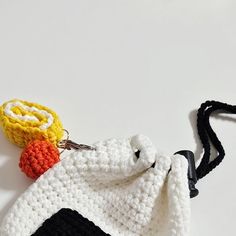 there is a crocheted bag with a small object on it's side