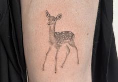 a small deer tattoo on the arm