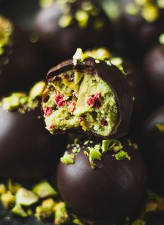 chocolate covered eggs with pistachios and nuts on the top one is half eaten