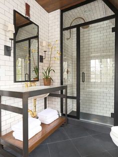 a white tiled bathroom with black and gold accents