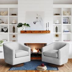 a living room with two chairs and a fire place in the middle of the room