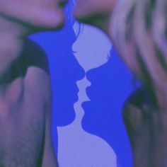 two people kissing each other in front of a blue and white background with the image of a woman's face