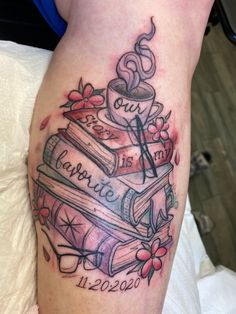 a tattoo on the leg of a woman with books