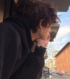 a woman with curly hair looking out the window