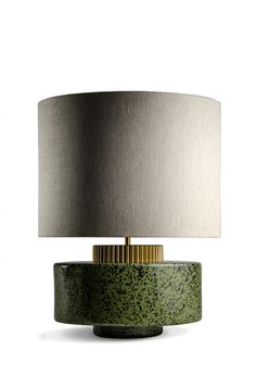 a green table lamp with a silver shade on it's base and a black drum light