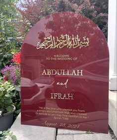 a welcome sign to the wedding of abdulah and irrah in front of some flowers