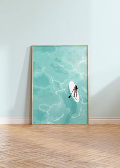 a person on a surfboard in the water with a blue wall behind them and wood flooring