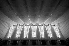 the inside of a large building with many windows and lights on it's ceiling