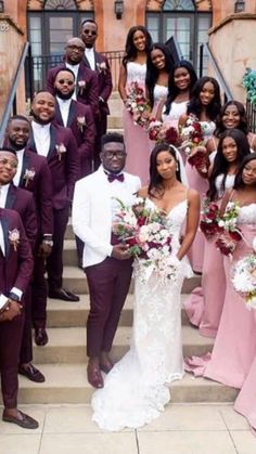 the bride and grooms are posing for a photo on the steps in front of their wedding party