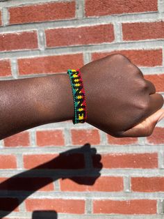 Runner Finisher Bracelet Red Yellow Green Beads with RUNNER in all black beads  One side : Runner Other side : Blank Handmade in Ghana This product was designed by nature to fit the wrist. PLEASE use lotion or soap and water to help get the bracelet over your hand. Friendship Bracelets With Black Round Beads, Black Beaded Friendship Jewelry, Black Beads Jewelry For Friendship, Adjustable Black Beaded Friendship Bracelets, Black Bohemian Letter Beads, Bohemian Black Letter Beads, Casual Black Round Beads Friendship Bracelets, Casual Black Round Beads Friendship Bracelet, Casual Multicolor Jewelry With Black Beads