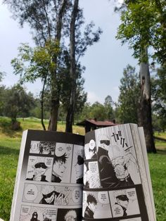 an open comic book sitting on top of a grass covered field