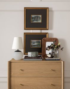 a wooden dresser topped with pictures and vases