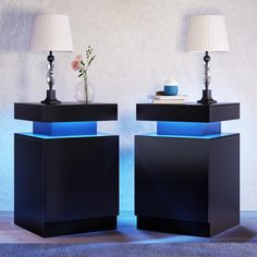 two black and blue side tables with lamps on them, one has a flower in it