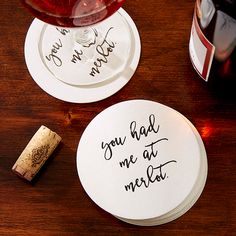 two coasters that say you had me at merlot and one has a bottle of wine