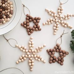 christmas decorations made out of chocolates and nuts on a white table with pine cones