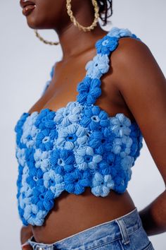 a close up of a person wearing a top with crocheted flowers on it