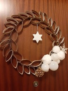 a christmas wreath made out of metal strips and plastic balls on a wooden surface with a star ornament hanging from the center