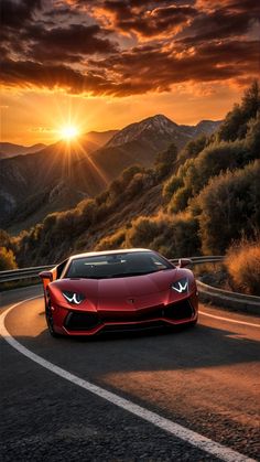 a red sports car driving down a winding road at sunset with the sun setting in the background