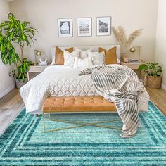 a bedroom with a bed, rugs and pictures on the wall above it is shown