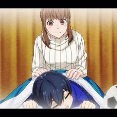 a woman sitting on top of a bed next to a man in front of a soccer ball