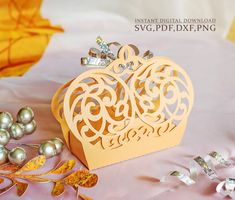 a paper cut out of a heart on top of a table with pearls and other decorations