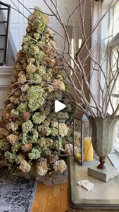 a living room with a christmas tree in the corner and decorations on the table next to it