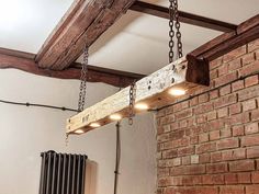 a wooden beam suspended from the ceiling in a room with brick walls and exposed beams