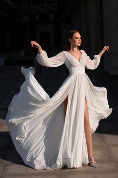 a woman in a white dress is standing on the sidewalk with her legs spread out