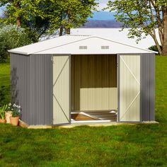 a small shed with the doors open on grass