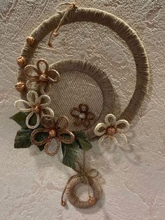 two wreaths with flowers and ribbons hanging on the wall in front of a white background