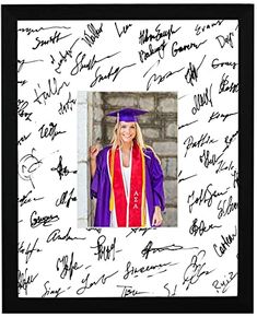 a woman wearing a graduation cap and gown with autographs on the wall behind her