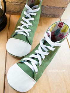 a pair of green and white shoes sitting on top of a wooden floor next to a clock