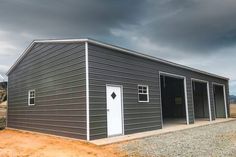 a large metal building sitting on top of a dirt field