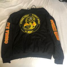 I Am Selling A Cobra Kai Hoodie, Brand New. It Has Never Been Worn. The Reason Is Because It Was Originally A Present For My Little Sister Who Loves The Show Cobra Kai On Netflix, But It Turned Out She Already Had A Cobra Kai Hoodie And Did Not Seem Interested In Owning Another One. Cobra Kai Hoodie, Yellow Tops With Ribbed Cuffs For Streetwear, Yellow Hooded Top With Graphic Print, Urban Yellow Graphic Print Sweatshirt, Urban Yellow Long Sleeve Tops, Cobra Kai Logo, Daniel Karate Kid, Karate Kid, Sweaters Crewneck