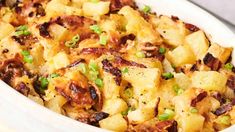 a casserole dish with potatoes and green onions in a white bowl on a table