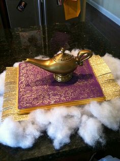 a golden bowl sitting on top of a purple and gold table cloth covered in fluffy white cotton