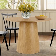 a wooden table with two chairs and a bowl of fruit on the table next to it