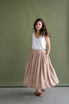 Feminine meets practical - this wonderfully woven sweet button-down skirt is flattering, has a softly gathered waist, deep pockets, and pairs well with any kind of fashion sense. Functional buttons descending down the front, create the perfect summer day look. Carefully gathered folds both in front and back create a beautiful A-line shape. It is made of natural linen, which makes you feel comfortable, free in movements and also very special. It fastens with front buttons and sits best when high Tiered Skirt With Pockets For Day Out, Tiered Maxi Skirt With Pockets For Day Out, Chic Relaxed Fit Skirt With Pockets, Casual Midi Voluminous Skirt, Long Skirt With Pockets For Daywear, Spring Flared Skirt With Button Closure, Flared Skirt With Button Closure For Spring, Daywear Flared Skirt With Pockets, Flared Skirt Bottoms With Button Closure For Spring