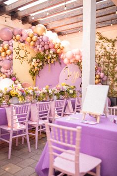 tables and chairs are set up with purple linens, white tablecloths, and balloons