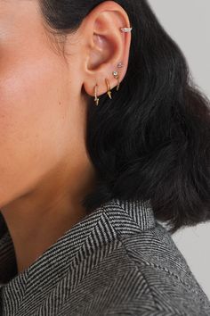 a close up of a person wearing an ear cuff with two small stars on it