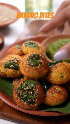 a plate full of food that includes spinach and other foods, with the words handvo bites above it