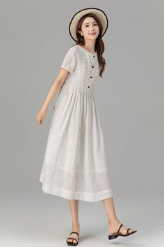 The crisp white color and subtle stripes exude sophistication, while the flattering silhouette and breathable linen fabric ensure comfort all day long. Whether for a casual outing or a special occasion, this dress is bound to turn heads and make a lasting impression. DETAILS * 100% linen  * White cotton lining * Striped linen dress * Two seam pockets * Front buttons closure * Mid-calf length * House dress * Perfect for spring, summer MODEL SIZE Bust 85 cm(33.4")  Waist 67 cm(26.7")  Height 168cm Striped Midi Dress With Buttons For Summer, Casual Striped Linen Dress, White Casual Linen Midi Dress, White Casual Midi Linen Dress, Elegant White Linen Dress With Buttons, Chic Striped Linen Dress, White A-line Maxi Dress With Buttons, Striped Daywear Dress With Buttons, Casual White A-line Linen Dress