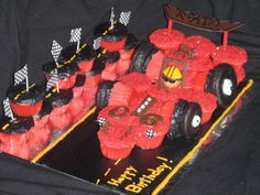 a birthday cake made to look like a race car with cupcakes in the shape of cars